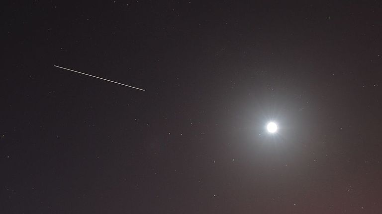 This long-exposure photo shows the International Space Station as it streaks across the sky past the Moon before the launch of the space shuttle Discovery April 5, 2010 at the Kennedy Space Center in Florida. Discovery will carry a multi-purpose logistics module filled with science racks for the laboratories aboard the International Space station. AFP PHOTO/Stan HONDA (Photo credit should read STAN HONDA/AFP via Getty Images) 